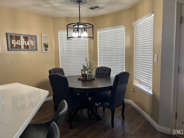 dining area featuring a chandelier, dark wood finished floors, visible vents, and baseboards