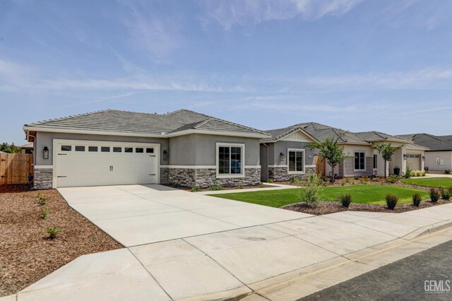 11118 Irontooth Ave, Bakersfield, CA 93311 - view of front of home with stone siding, stucco siding, a garage, concrete driveway, and a tile roof