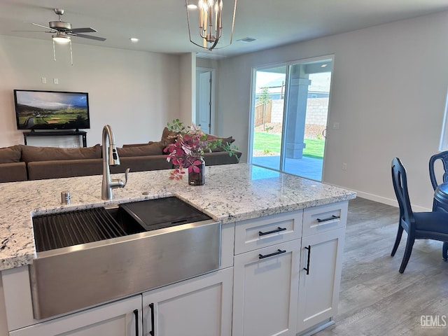 11118 Irontooth Ave, Bakersfield, CA 93311 - kitchen featuring a sink, open floor plan, white cabinetry, and recessed lighting
