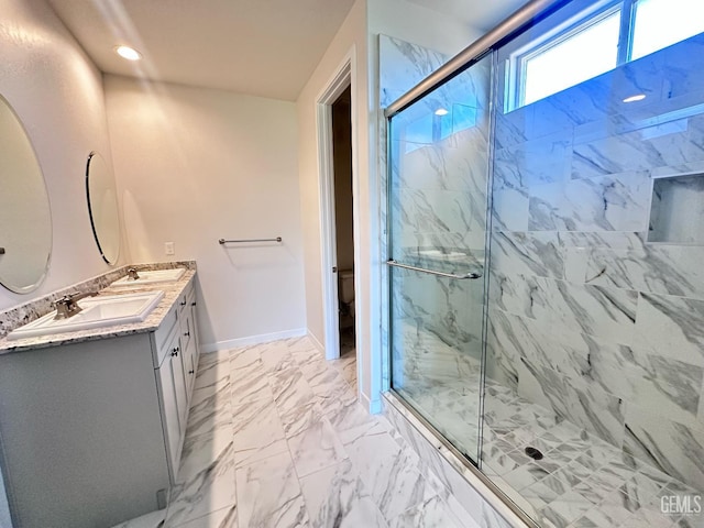 11118 Irontooth Ave, Bakersfield, CA 93311 - full bath with a marble finish shower, double vanity, baseboards, marble finish flooring, and toilet