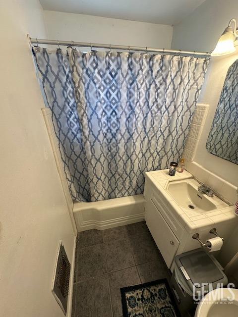 full bathroom with tile patterned floors, shower / bath combo, toilet, and vanity