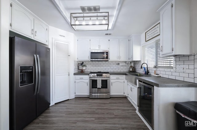 kitchen with white cabinetry, sink, stainless steel appliances, wine cooler, and backsplash