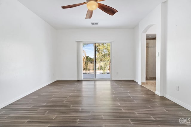 5219 Port Dr, Bakersfield, CA 93312 - spare room with arched walkways, a ceiling fan, and dark wood-type flooring