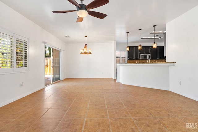5219 Port Dr, Bakersfield, CA 93312 - unfurnished living room with light tile patterned floors, a chandelier, and ceiling fan