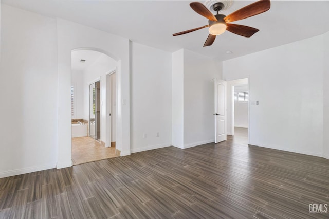 5219 Port Dr, Bakersfield, CA 93312 - empty room featuring arched walkways, ceiling fan, and dark wood finished floors