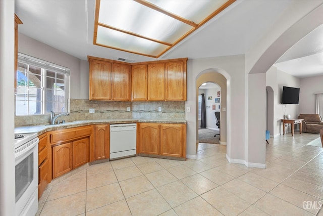3601 Villa Lante St, Bakersfield, CA 93308 - kitchen featuring white appliances, light countertops, arched walkways, backsplash, and light tile patterned floors
