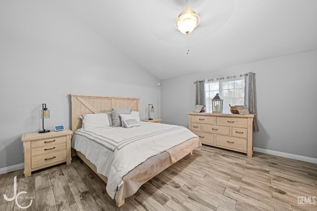 bedroom with light wood finished floors, vaulted ceiling, and baseboards