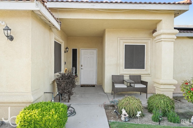 entrance to property featuring a tile roof and stucco siding