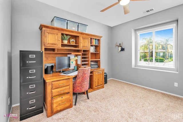 office area featuring baseboards, visible vents, ceiling fan, and light colored carpet