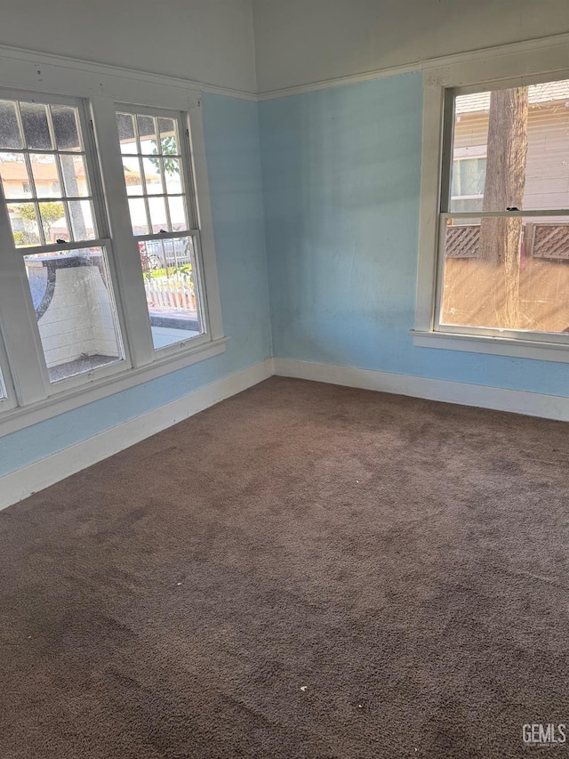 empty room featuring carpet floors and baseboards