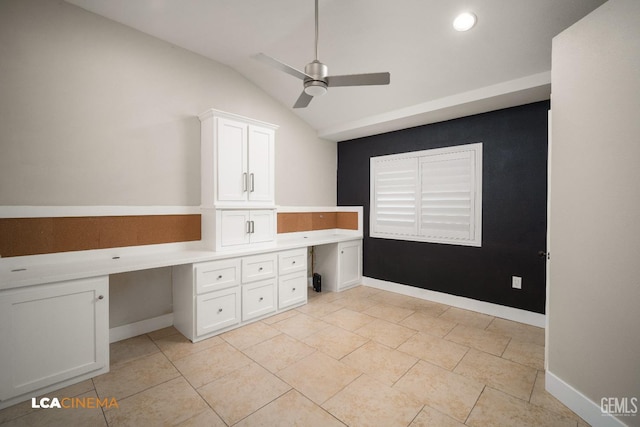 unfurnished office with light tile patterned floors, built in desk, vaulted ceiling, and ceiling fan