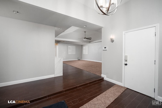 entryway featuring ceiling fan with notable chandelier and a high ceiling