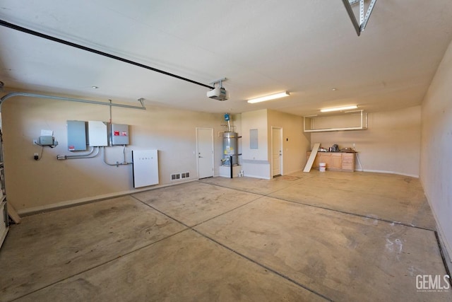 garage with a garage door opener, strapped water heater, and electric panel