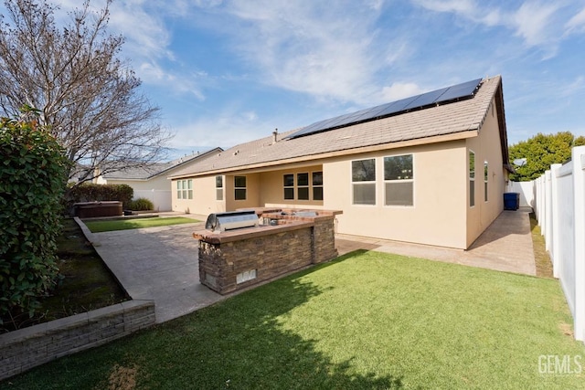 rear view of property with solar panels, a yard, and a patio area