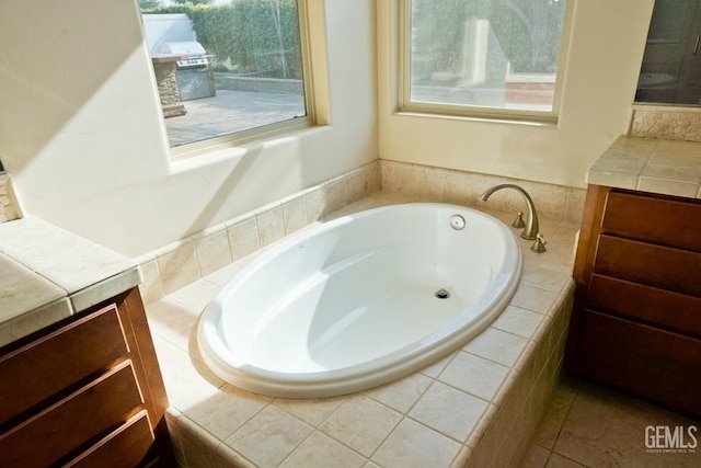 bathroom with vanity and a relaxing tiled tub