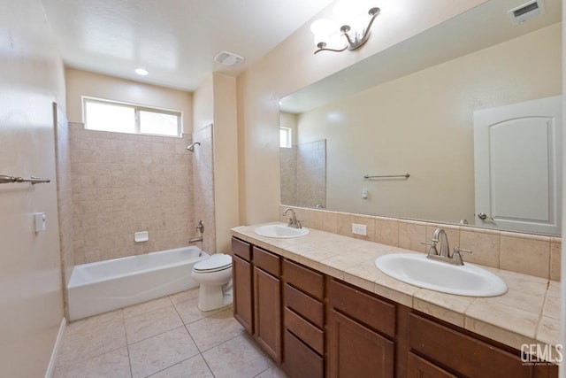 full bathroom featuring tiled shower / bath combo, vanity, tile patterned flooring, and toilet