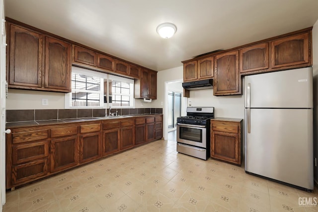 814 Eureka St, Bakersfield, CA 93305 - kitchen featuring stainless steel appliances, under cabinet range hood, dark countertops, and light tile patterned floors