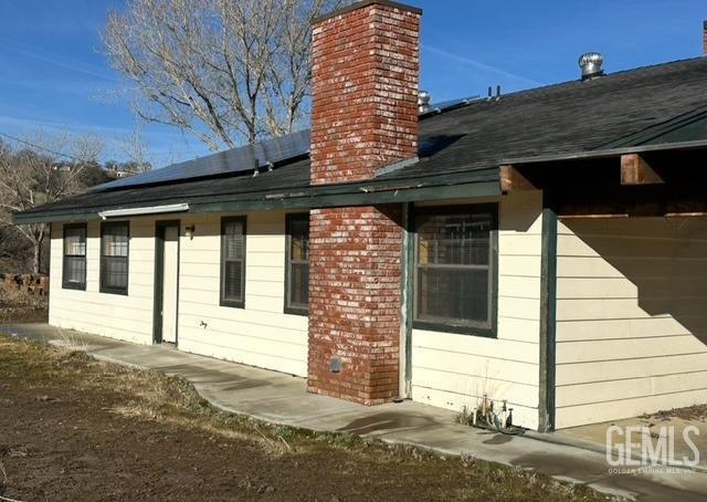 exterior space featuring a chimney and a hot tub