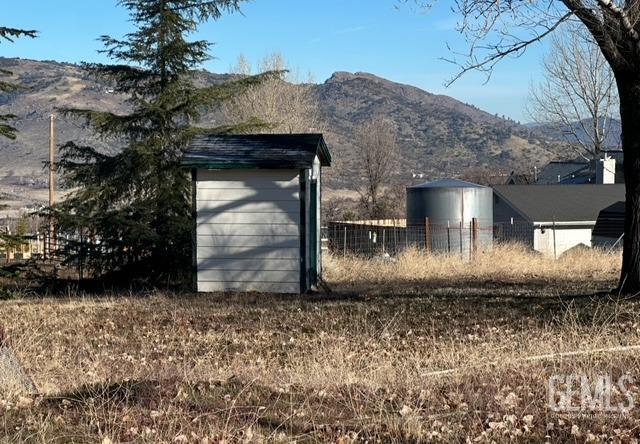 view of outbuilding with an outdoor structure, fence, and a mountain view