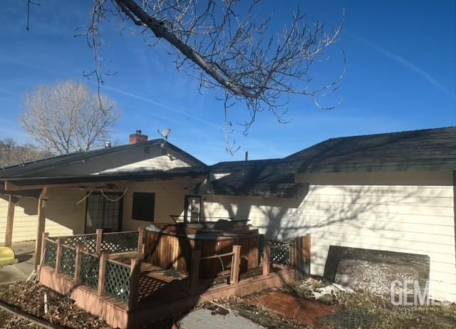 exterior space with a chimney and a hot tub