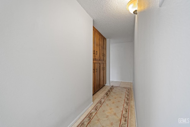 3504 Elm St, Bakersfield, CA 93301 - hallway with inlaid floor details, a textured ceiling, and baseboards