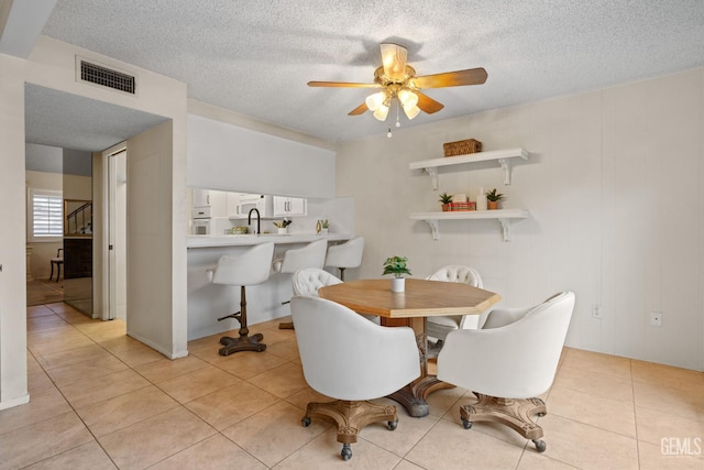 3504 Elm St, Bakersfield, CA 93301 - dining area with a ceiling fan, a textured ceiling, and light tile patterned floors
