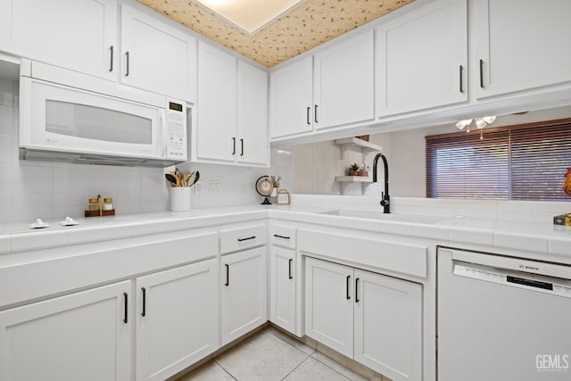 3504 Elm St, Bakersfield, CA 93301 - kitchen featuring white appliances, a sink, white cabinetry, decorative backsplash, and light tile patterned floors