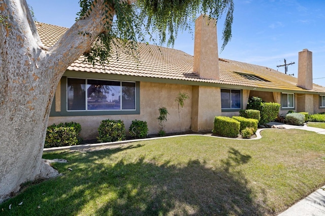 3504 Elm St, Bakersfield, CA 93301 - view of side of property with a tile roof, stucco siding, a yard, and a chimney