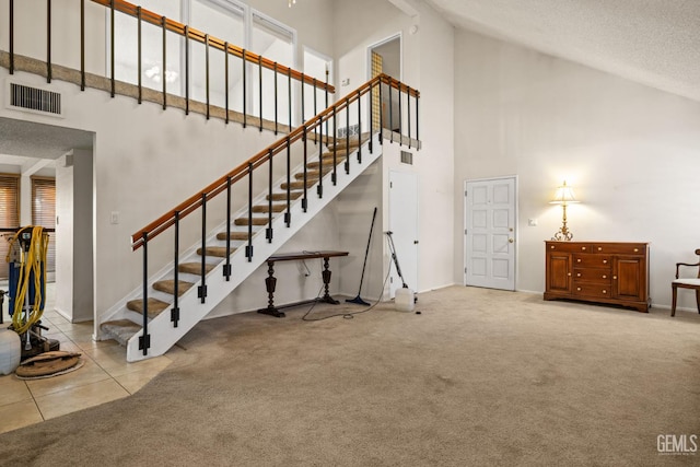 3504 Elm St, Bakersfield, CA 93301 - stairway with high vaulted ceiling, carpet floors, a textured ceiling, baseboards, and tile patterned floors