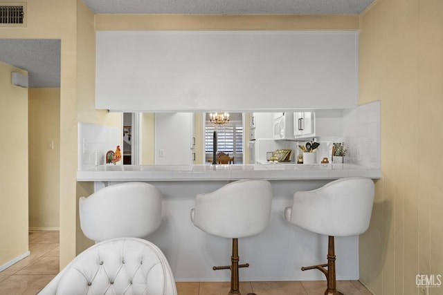 3504 Elm St, Bakersfield, CA 93301 - bar featuring a chandelier and light tile patterned floors