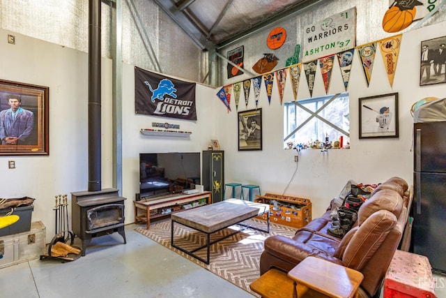 living room with a wood stove and concrete floors