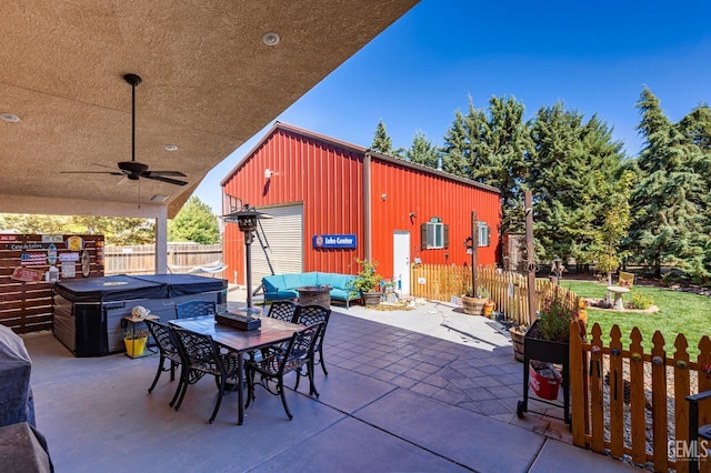 view of patio featuring a hot tub, ceiling fan, outdoor lounge area, and an outdoor structure