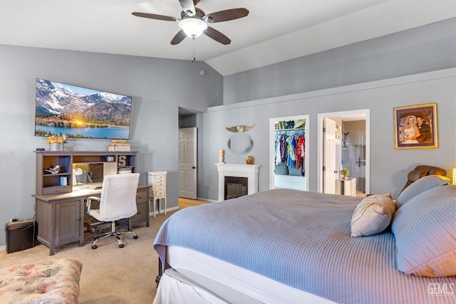 carpeted bedroom with ceiling fan, a walk in closet, a closet, and lofted ceiling