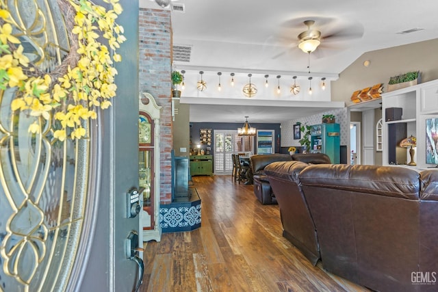 living room featuring brick wall, lofted ceiling, ceiling fan with notable chandelier, and dark hardwood / wood-style floors