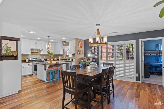 dining area with an inviting chandelier and light hardwood / wood-style flooring