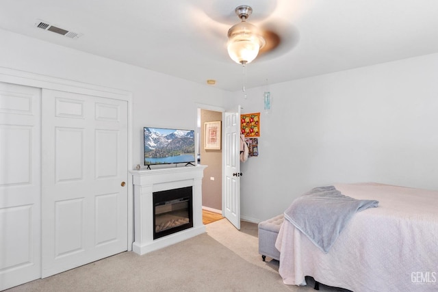 bedroom with light carpet, a closet, and ceiling fan