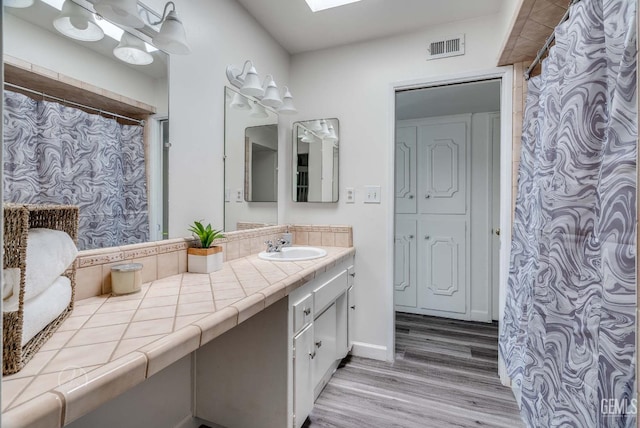 6201 Hartman Ave, Bakersfield, CA 93309 - bathroom with wood finished floors, vanity, a shower with curtain, and baseboards