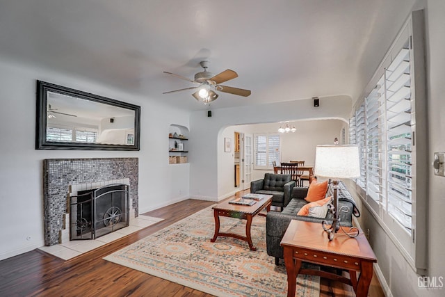 2849 Alturas Dr, Bakersfield, CA 93305 - living room featuring ceiling fan with notable chandelier, baseboards, wood finished floors, and a fireplace