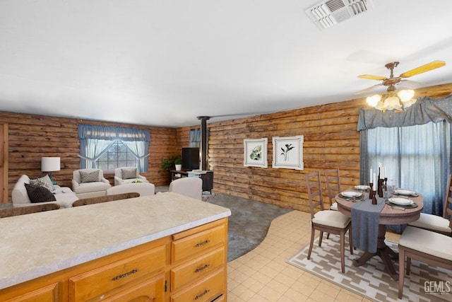 38579 Payne Way, Caliente, CA 93518 - kitchen with log walls, a ceiling fan, light countertops, a wood stove, and open floor plan
