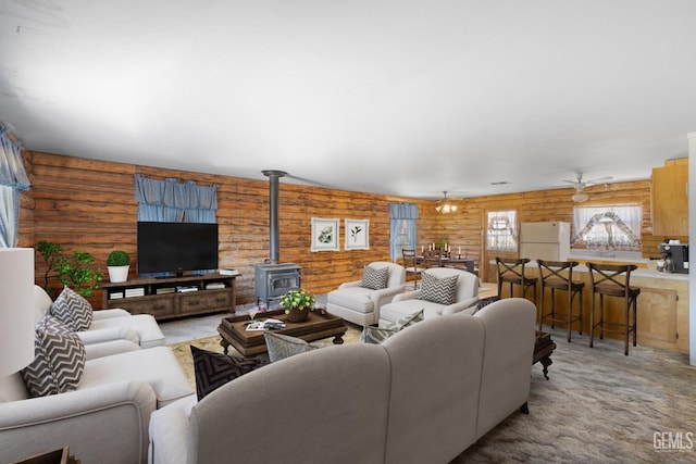 38579 Payne Way, Caliente, CA 93518 - living area with log walls, a wood stove, a ceiling fan, and carpet flooring