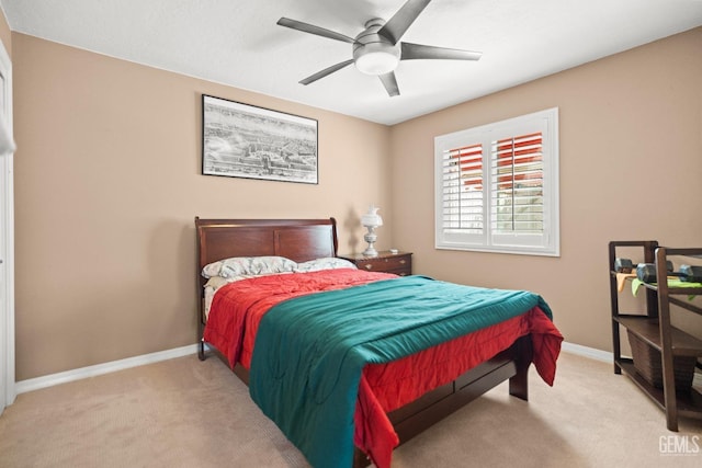 carpeted bedroom with ceiling fan and baseboards