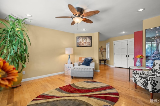 living area featuring wood-type flooring, baseboards, a ceiling fan, and recessed lighting