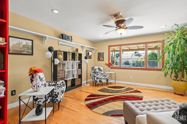 living area featuring recessed lighting, visible vents, a ceiling fan, wood finished floors, and baseboards