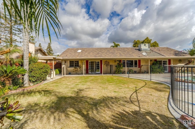 view of front facade with a patio area, fence, a front lawn, and stucco siding