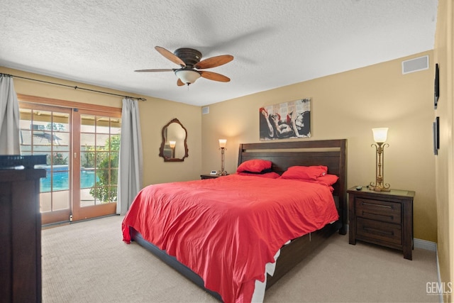 carpeted bedroom with access to exterior, visible vents, a textured ceiling, and a ceiling fan