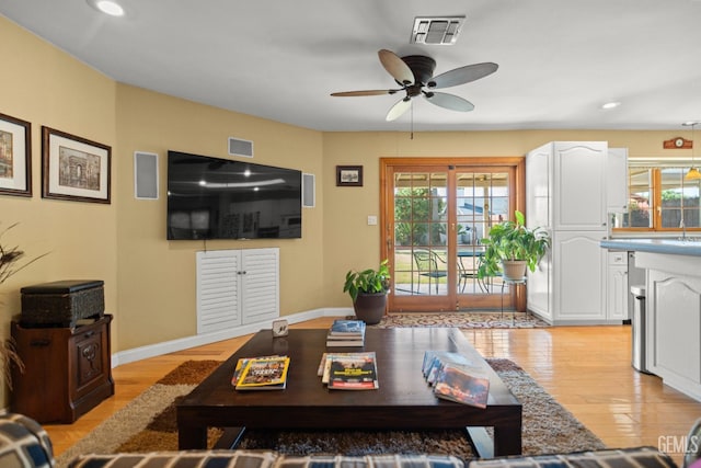 living area with a wealth of natural light, baseboards, visible vents, and light wood finished floors