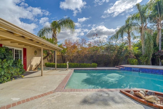 outdoor pool with a patio area and fence