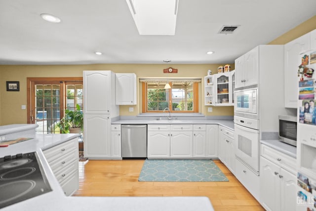 kitchen with stainless steel appliances, a wealth of natural light, a skylight, and visible vents