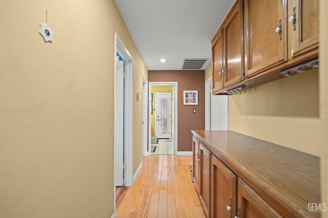 hall featuring recessed lighting, light wood-type flooring, visible vents, and baseboards