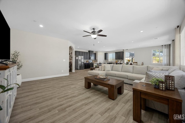 5503 Giverny Way, Bakersfield, CA 93306 - living room featuring a ceiling fan, arched walkways, recessed lighting, baseboards, and light wood-style floors